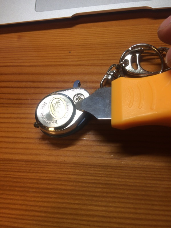 裏がまこじ開け器を差し込んで蓋を外す